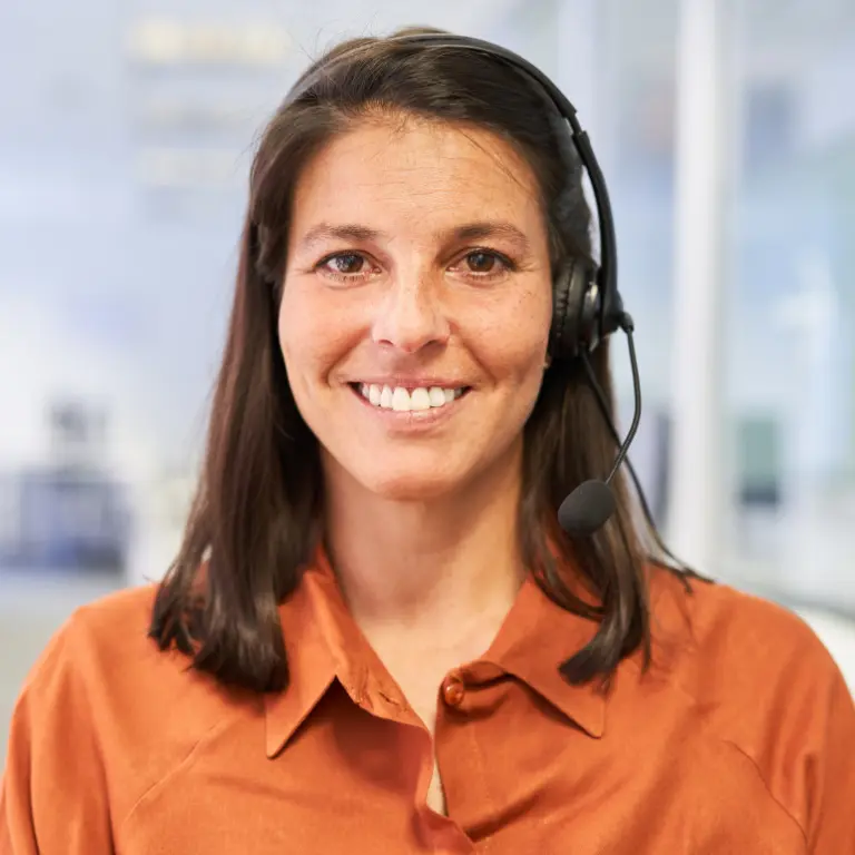 Freundliche Kundenberaterin mit Headset im Kundenservice steht für moderne Jobs für Quereinsteiger im Ruhrgebiet.